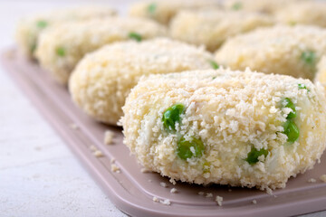 Cutlets from white fish fillet, potatoes and green peas. Semi-finished product. Baby or diet food. Close-up