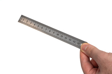 Hand holding a stainless steel ruler on isolated white background. 15cm metal ruler in hand. Precision measuring tool for length and drawing. Closeup