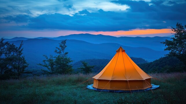 Illuminated tent on mountaintop at sunset