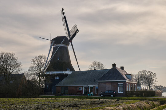 Traditional hulling and grist mill De Hoop with farmhouse in Holwerd, Netherlands