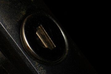 Detailed shot of a lock's key slot, showing the inner mechanism and a subtle gleam against a black...