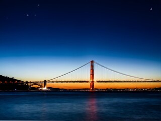 Fototapeta premium Golden Gate Bridge at Twilight with a Crescent Moon