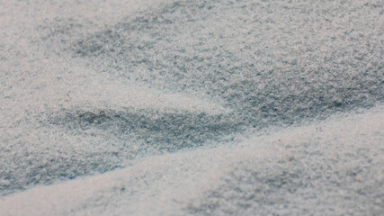 Close-up texture of a light blue and white fabric with a soft, fuzzy surface.
