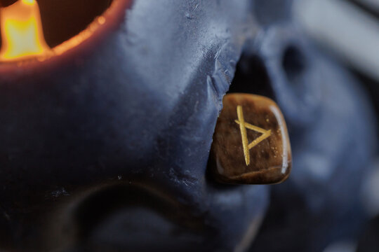 Thurisaz symbol on dark background.
