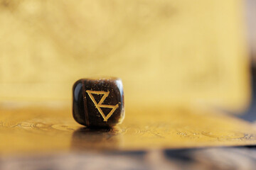 Berkana rune closeup on golden background