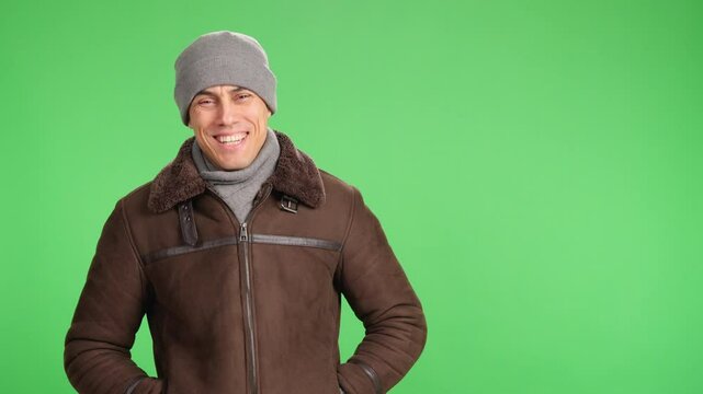 Smiling man wearing winter clothes on green screen background