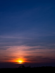 Sunset sky and dramatic clouds in evening Summer,Nature background sunrise reflection over forest trees in morning Spring,Vertical beautiful golden hour with twilight, dusk sky while sundown in Winter