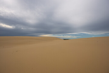 Beautiful sand dune landscape with cloudy sky.