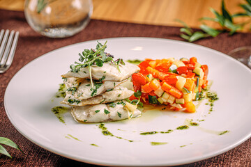 Portion of gourmet white fish with sauted vegetables