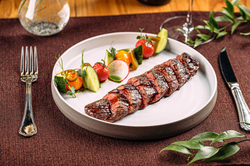 Portion of grilled sliced beef steak with vegetable garnish