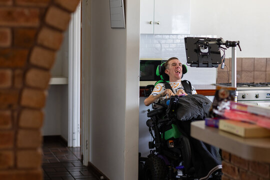 Young man with disability on his wheelchair looking on an acc screen