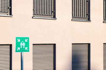 Green assembly point sign showing gathering place in case of emergency