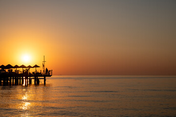 Beautiful sea view at sunrise, sunset. Silhouette of the pier. Rest at the sea, in the hotel, relaxation