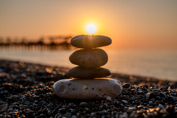 creative shot sun over cairn, the concept of balance, tranquility, relaxation, calm