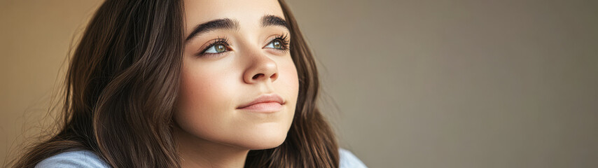 Fototapeta premium Contemplative young woman gazes thoughtfully toward the light in a serene indoor setting