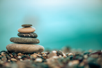 A pyramid of stones on a pebble beach by the sea, the concept of balance, calm, tranquility, relaxation with copy space
