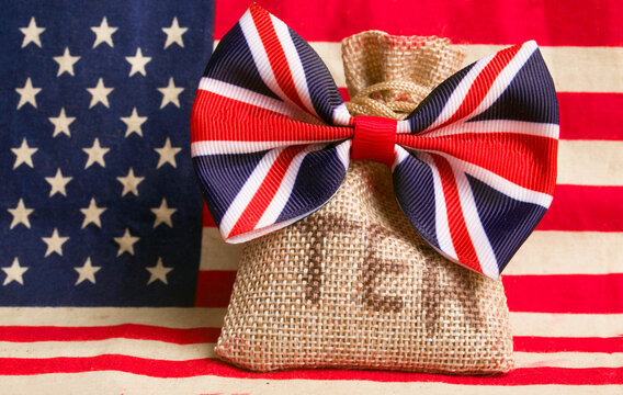 bag of english tea against the background of the us flag. concept of boston tea party and the struggle for us independence - Powered by Adobe
