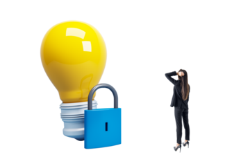 Businesswoman in black suit looking at large locked lightbulb. Isolated on white background. Concept of blocked creativity and innovation