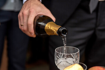 Man pours champagne into a crystal glass