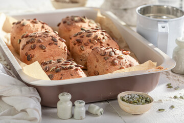 Rustic and hearty pumpkin seed buns cooling in cozy kitchen.