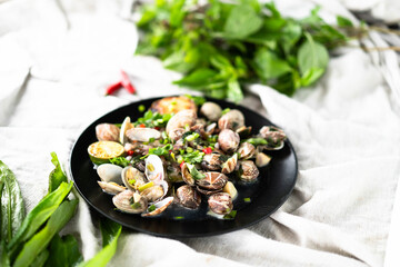 Clams and mussels are beautifully arranged with garlic and fresh herbs on a plate.