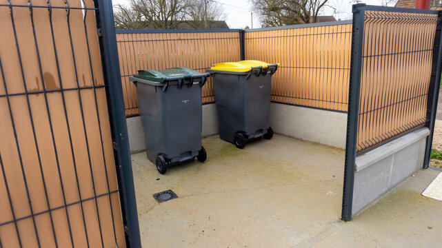 deux bacs de poubelles pour d&eacute;chets m&eacute;nagers et tri s&eacute;lectif dans un box ext&eacute;rieur