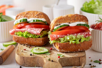 A freshly prepared sandwich with crisp vegetables and savory salami.