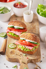 A flavorful and delicious sandwich with salami, tomatoes, and cucumbers.