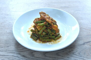 spicy stir fried slice yard long bean with fat pork and lemon grass in curry sauce on plate
