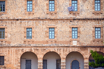 An old stone building with a Greek flag, Syntagma Square, Nafplio,Greece