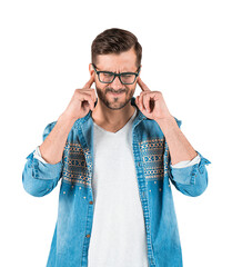 Young man in denim shirt and glasses covering ears with fingers, expressing discomfort or noise...