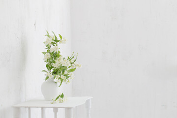 jasmineflowers in vase on background old wall