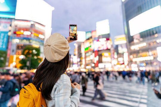 Young woman tourist enjoying and shopping at Shibuya crossing the largest and popular pedestrian scramble crossing in Tokyo
