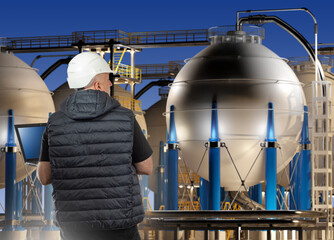 Man technologist at industrial enterprise. Engineer with laptop near factory. Manufacture...