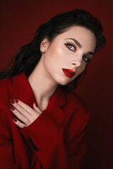 Naklejka premium Young Woman In Red Suit With Red Lips Posing On The Red Background