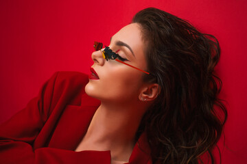 Young Woman In Red Suit With Red Lips And Sunglasses Posing On The Red Background