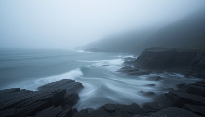 Obraz premium Ocean waves crashing against the rocky shore on a foggy day