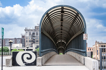 The 4th Street Bridge covered walkway in downtown Waterloo, Iowa on a beautiful summer day with clouds in the sky.