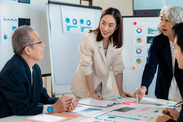 Asian businesspeople working together in modern office, collaborating on project and analyzing financial data