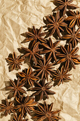Anise stars pattern, above view close up flavor spices dried anise seeds on paper, still life with natural condiments, aromatic ingredient for cooking, rustic style food background, gastronomy theme