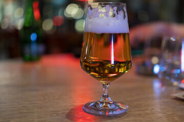 Golden Beer in Elegant Glass on Wooden Bar