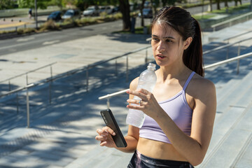 Young woman hydrating after outdoor workout session