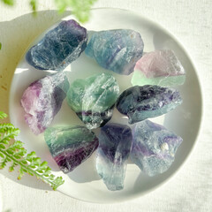 A stunning fluorite crystal in sunlight, surrounded by greenery. Known for healing, clarity, and...