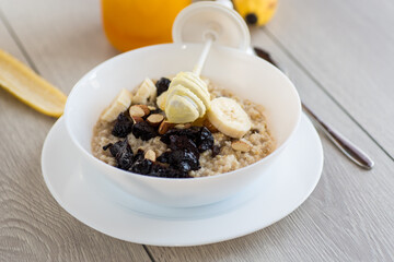 Healthy oatmeal with banana, nuts and prunes