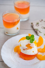 Fototapeta premium Layered fruit dessert with jelly, cream and fresh mint on a wooden table