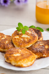 Appetizing cheese pancakes with a golden crust and a drop of honey
