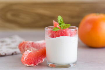 Natural fermented milk yogurt with citrus fruits on a wooden table