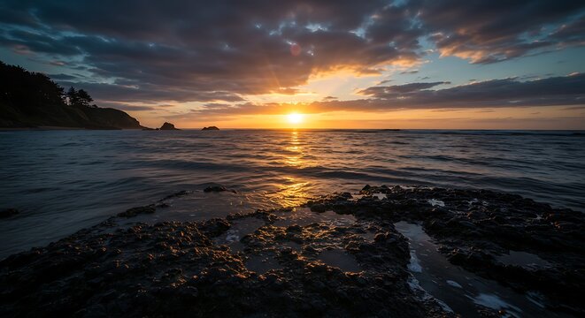Dramatic Ocean Sunset Over Rocks and Water with Coastal Forest View