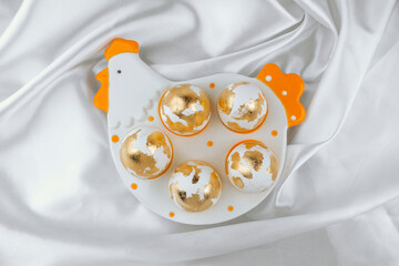 Easter gold eggs in a egg holder plate , top view. Easter banner.