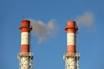 Smoking pipes on clear sky background. Concept of steam plant, air pollution, heating season or factory chimney